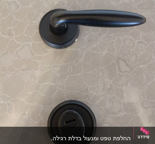 ידית ודלת עם מנעול על רקע שיש אפור